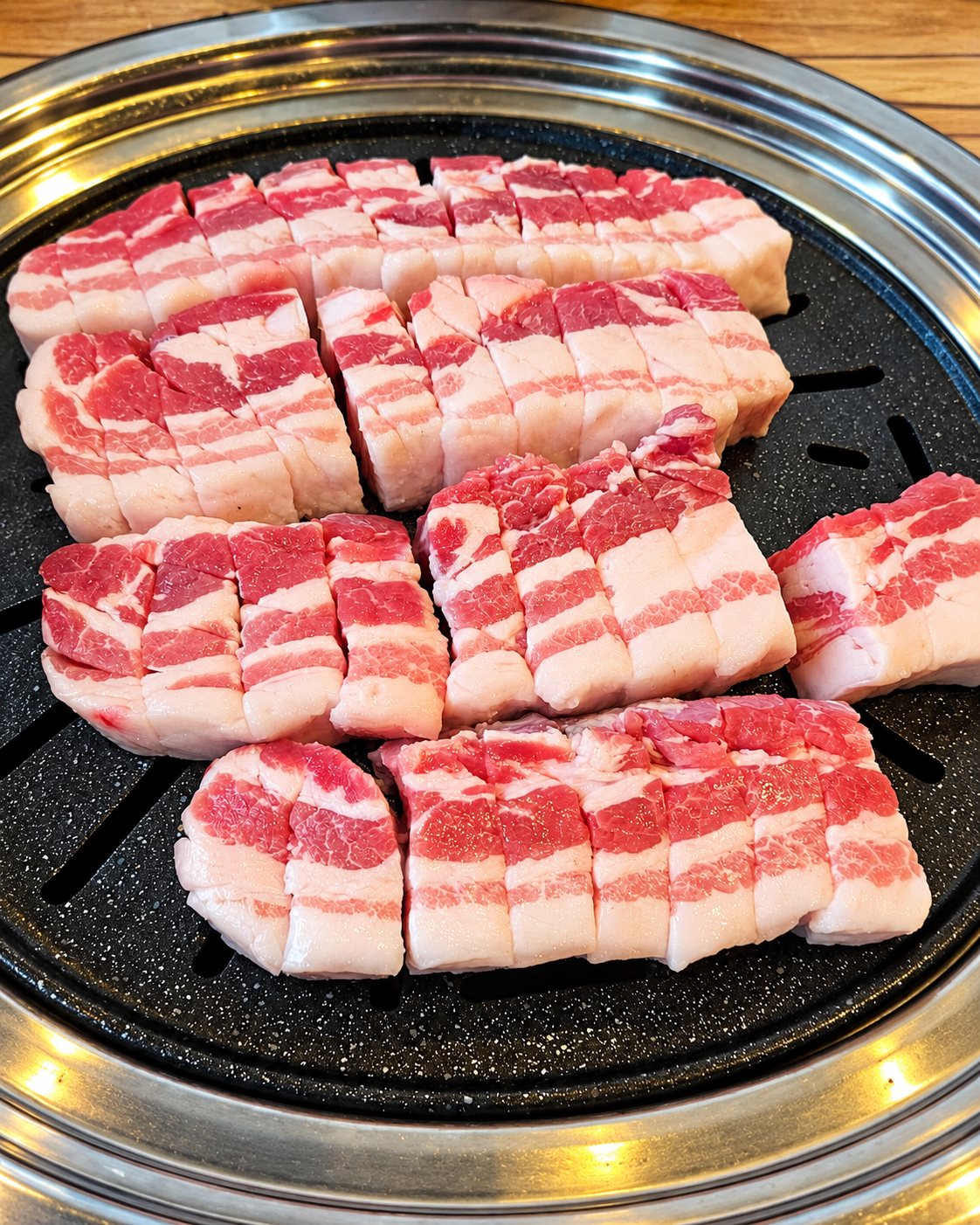 둥근 불판 위에 올린 두툼한 생 숙성삼겹살