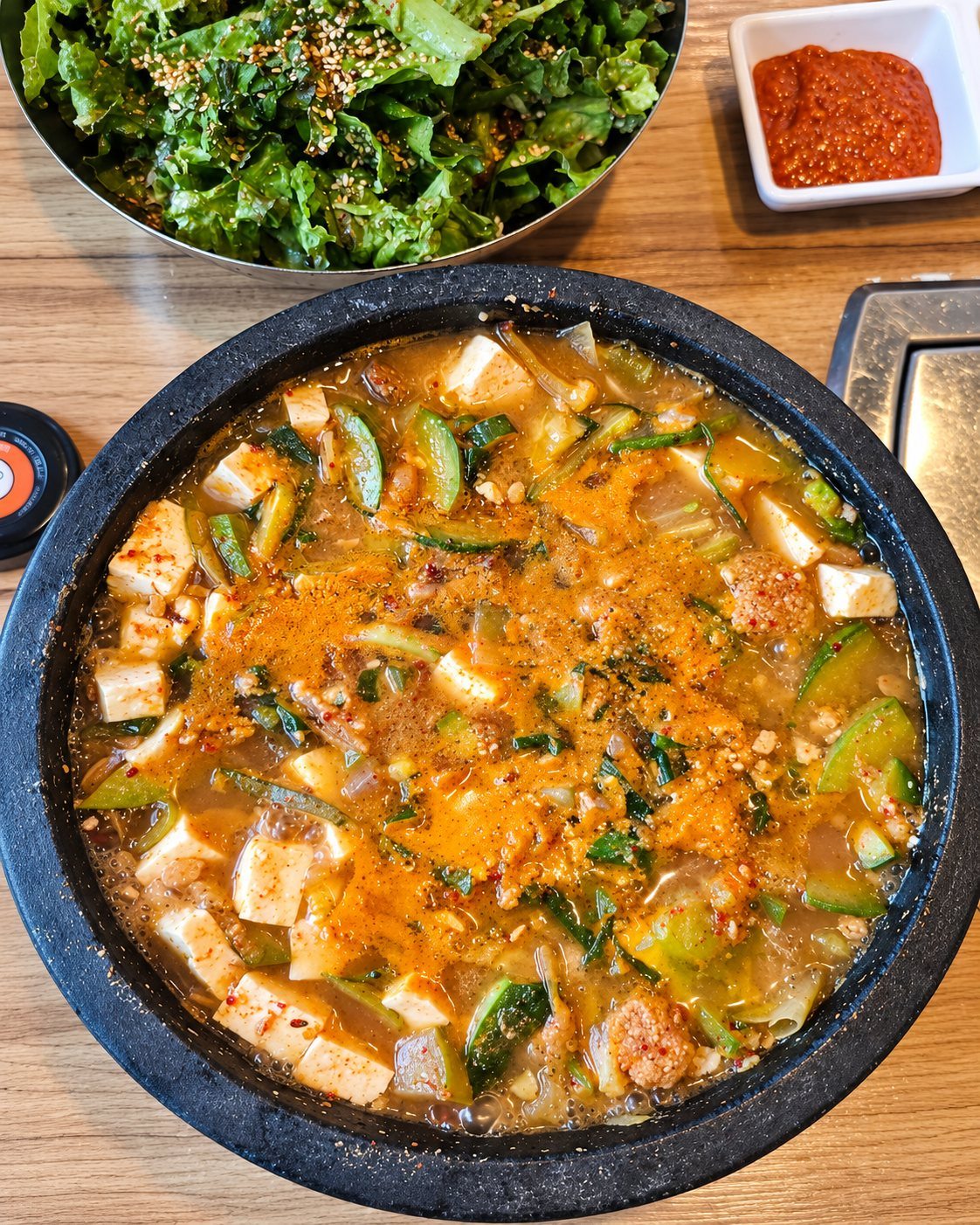 검은 냄비에 끓인 된장찌개(두부·애호박)와 쌈 채소